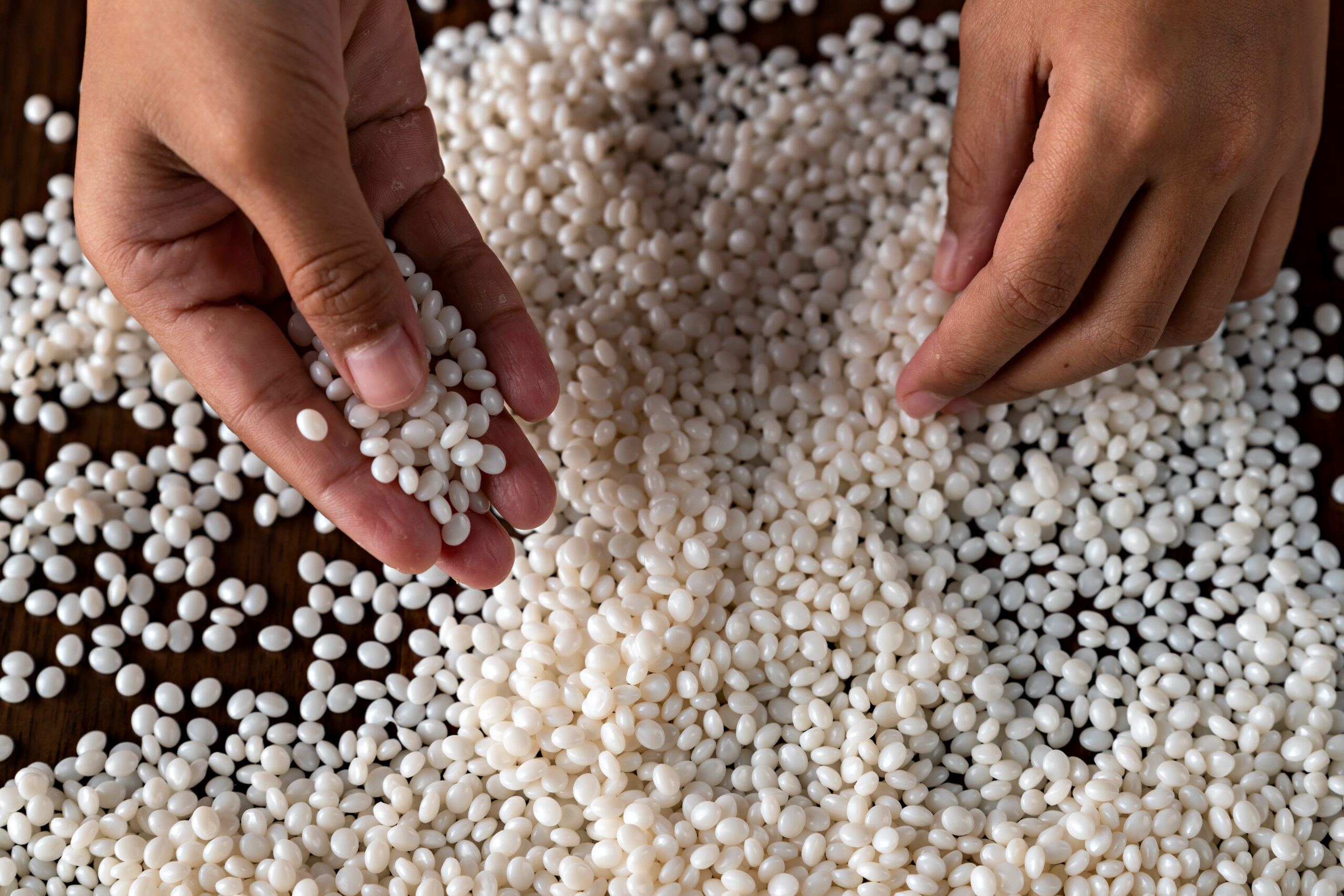 Close-up of plastic polymer granules, hand hold Polymer pellet, polymer plastic, compound polymer, Technology product of plastic chemical, green polymer, resin from petrochemical,